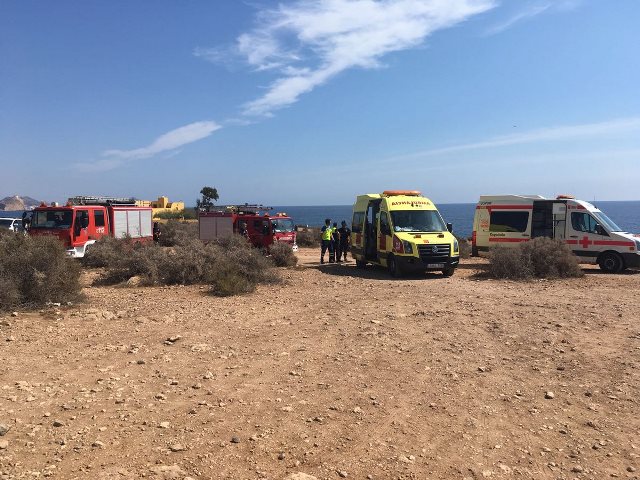 Bomberos y sanitarios rescatan y atienden a un hombre de una zona de rocas en la playa de Calarreona en Aguilas